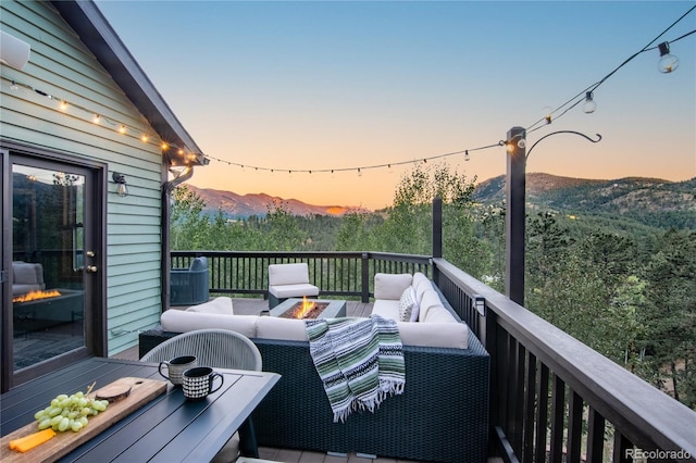288 Spring Vly, Bailey, CO 80421 - deck at dusk featuring an outdoor living space with a fire pit and a mountain view