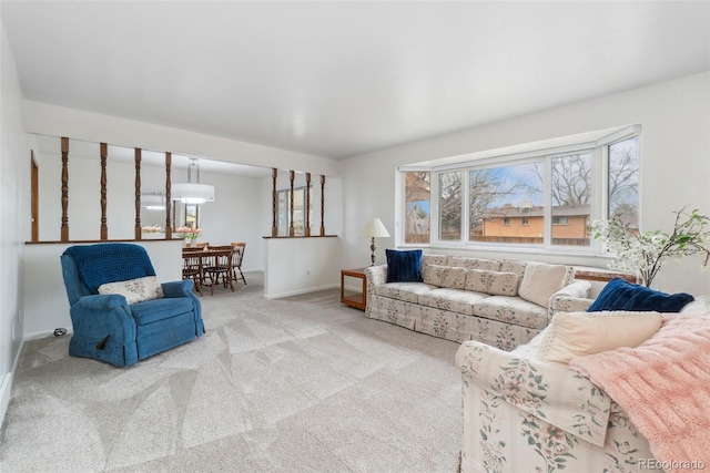 carpeted living area featuring baseboards