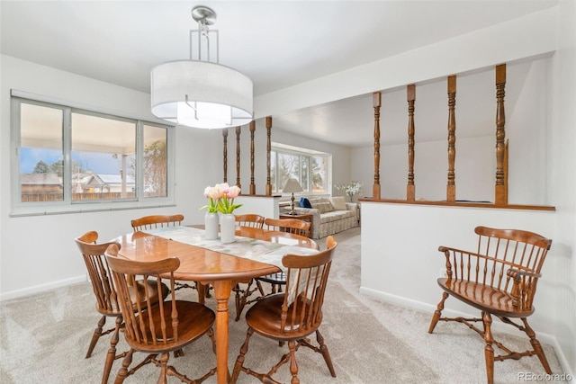 carpeted dining room with baseboards