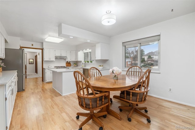 dining area featuring baseboards and light wood-style floors