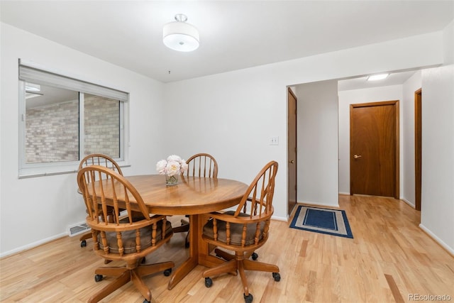 dining area featuring baseboards, visible vents, and light wood-type flooring