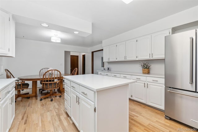 kitchen with light wood-style flooring, light countertops, and freestanding refrigerator