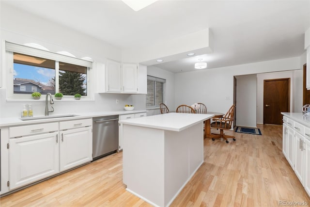 kitchen with white cabinetry, light wood finished floors, a sink, light countertops, and stainless steel dishwasher