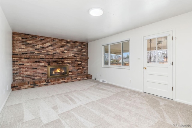 unfurnished living room with visible vents, baseboards, carpet, and a fireplace