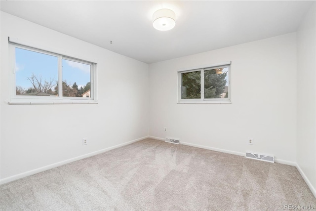 unfurnished room with visible vents, baseboards, and carpet