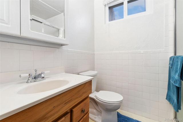 bathroom featuring vanity, a wainscoted wall, an enclosed shower, tile walls, and toilet