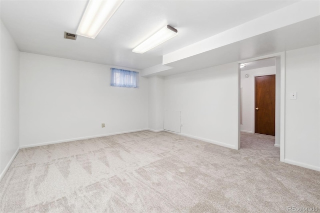 basement with carpet flooring, visible vents, and baseboards