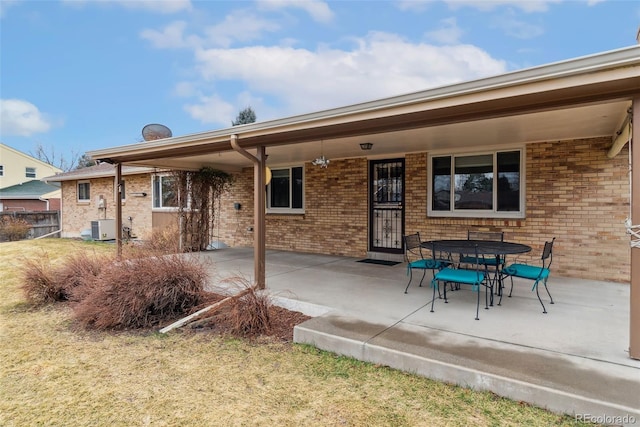 exterior space featuring brick siding, central air condition unit, and a patio