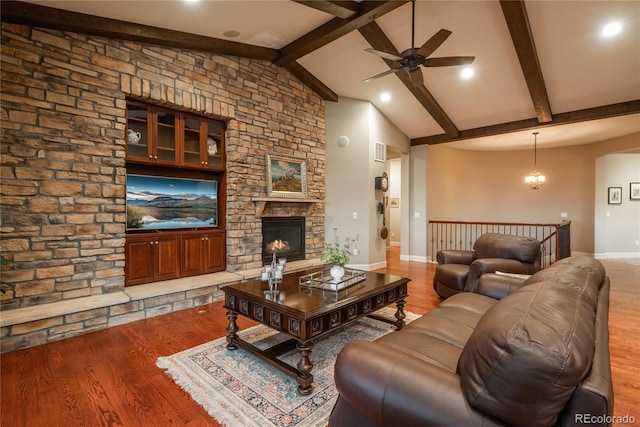 living room featuring wood finished floors, baseboards, vaulted ceiling with beams, a fireplace, and ceiling fan