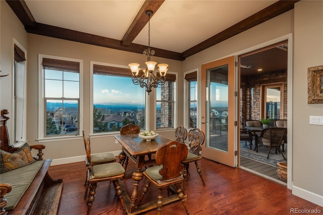 dining area with a notable chandelier, beamed ceiling, plenty of natural light, and wood finished floors