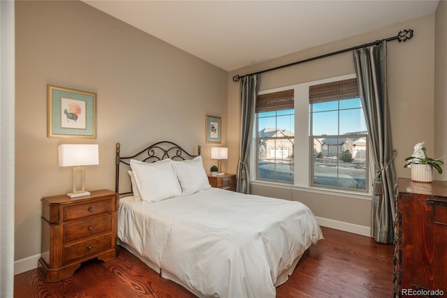 bedroom featuring baseboards and dark wood finished floors