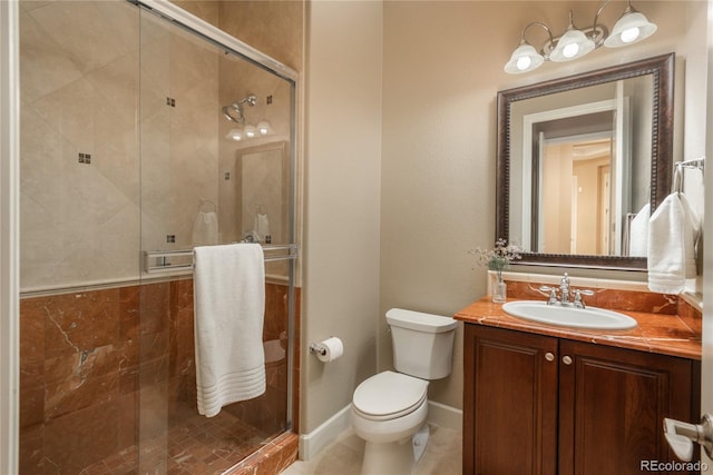 bathroom featuring baseboards, vanity, toilet, and a shower stall