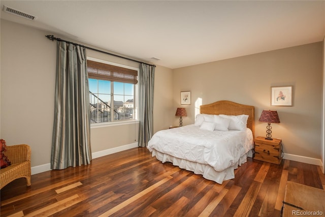 bedroom featuring visible vents, baseboards, and wood finished floors