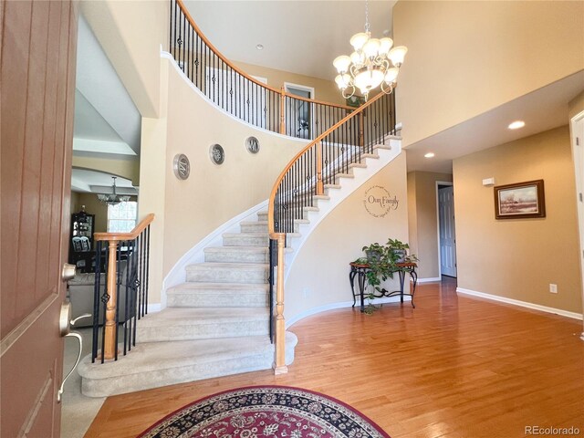 6035 S Paris St, Englewood, CO 80111 - foyer entrance featuring a high ceiling, a chandelier, stairway, wood finished floors, and recessed lighting