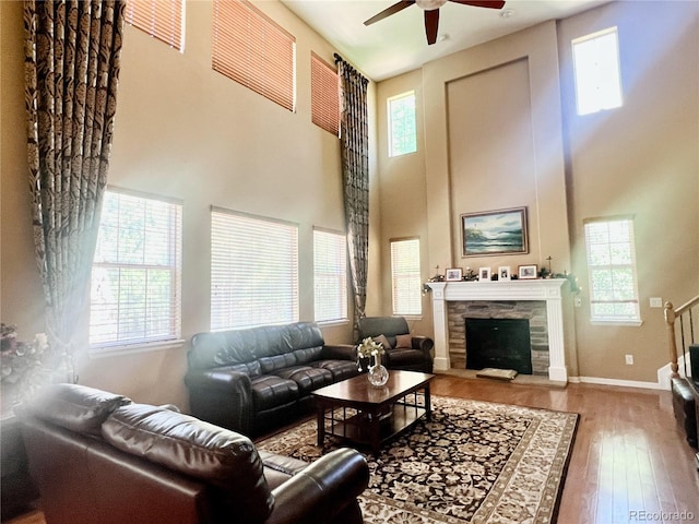 6035 S Paris St, Englewood, CO 80111 - living room with plenty of natural light, a ceiling fan, wood finished floors, a towering ceiling, and a fireplace