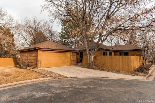 view of front facade featuring a fenced front yard, driveway, and a garage