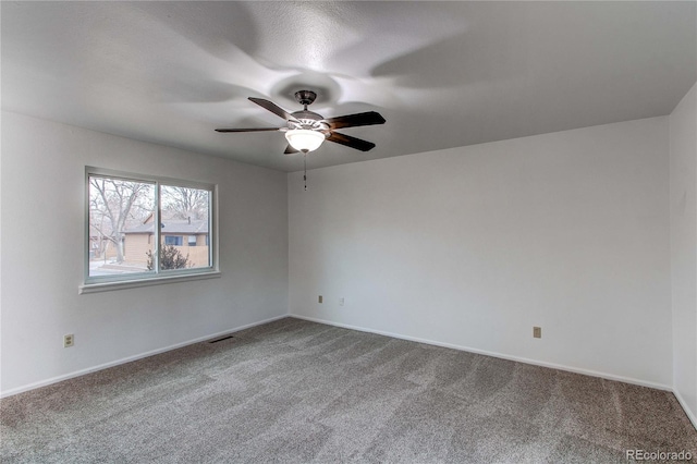 carpeted spare room featuring ceiling fan