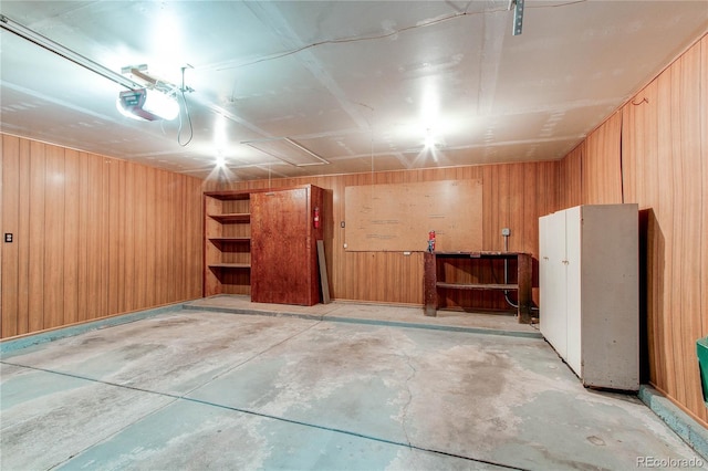 interior space with a garage door opener and wooden walls