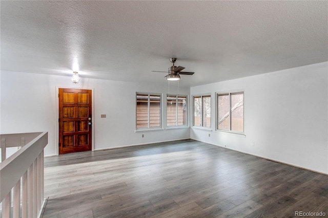 spare room with a textured ceiling, wood finished floors, and a ceiling fan