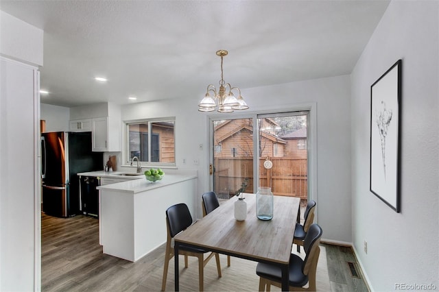 dining area featuring visible vents, baseboards, wood finished floors, a notable chandelier, and recessed lighting