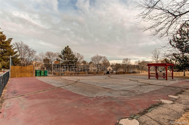 view of sport court featuring fence and a pergola