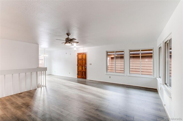 53 S Eagle Cir, Aurora, CO 80012 - unfurnished room with a ceiling fan, a chandelier, wood finished floors, and a textured ceiling