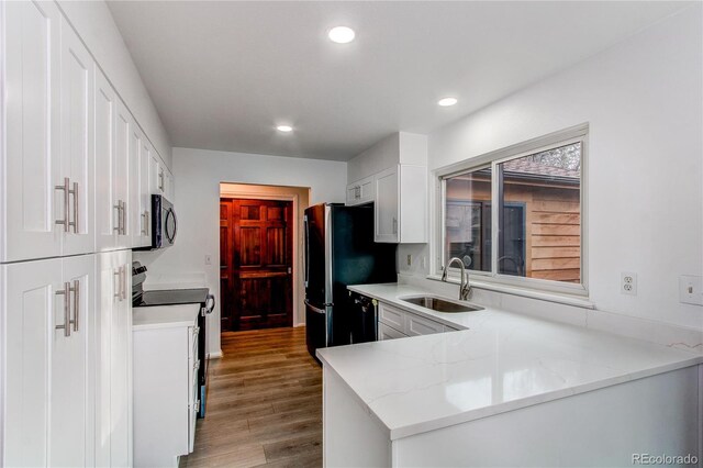 53 S Eagle Cir, Aurora, CO 80012 - kitchen with a sink, black appliances, white cabinets, wood finished floors, and recessed lighting