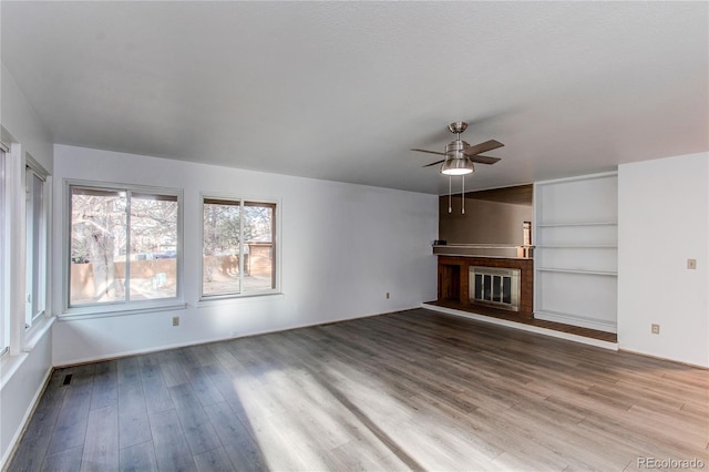 53 S Eagle Cir, Aurora, CO 80012 - unfurnished living room with a ceiling fan, wood finished floors, baseboards, and a fireplace