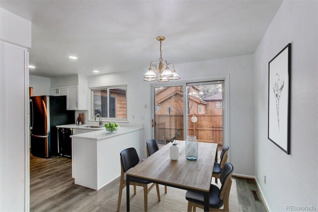 53 S Eagle Cir, Aurora, CO 80012 - dining area featuring wood finished floors, a chandelier, baseboards, and recessed lighting