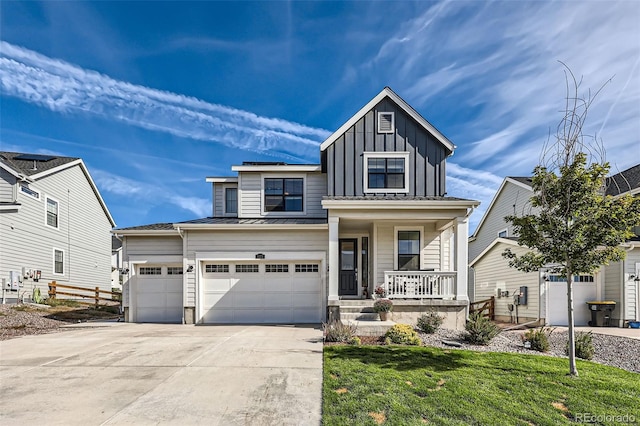 view of front of house featuring a garage, a front yard, and covered porch