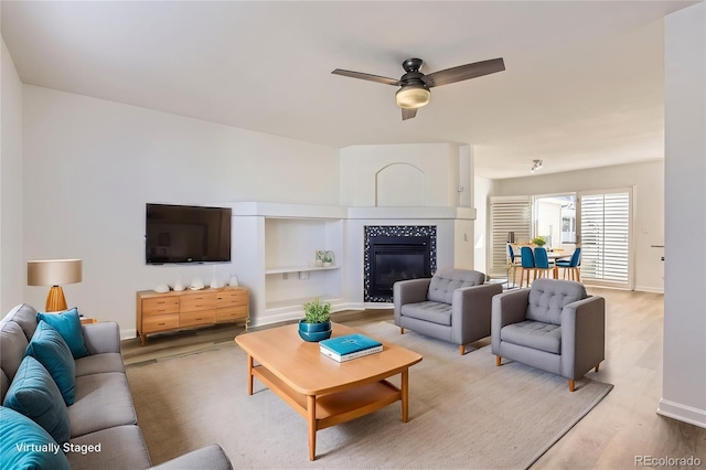 112 W Sterne Pkwy, Littleton, CO 80120 - living area featuring wood finished floors, ceiling fan, a tile fireplace, and baseboards