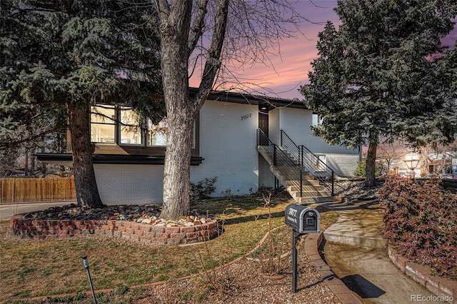 exterior space featuring a yard, brick siding, and fence