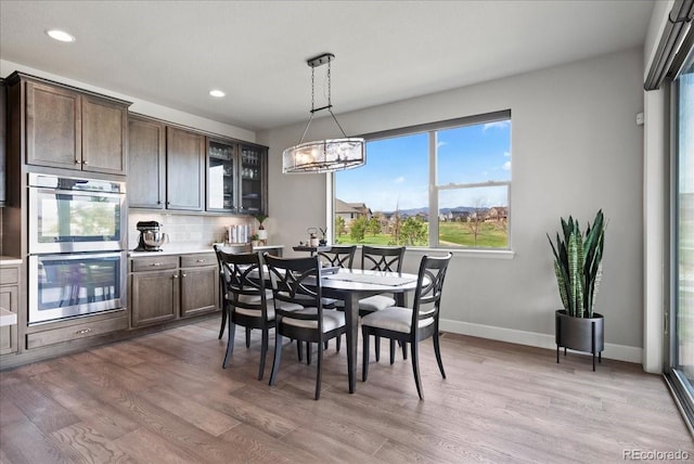 dining room featuring light wood-style floors, a healthy amount of sunlight, and recessed lighting
