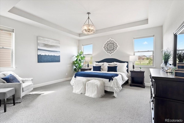 bedroom featuring baseboards, carpet flooring, and a tray ceiling