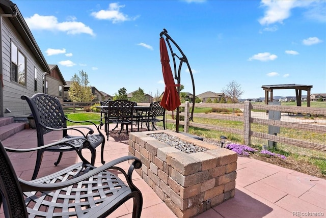 view of patio / terrace with an outdoor fire pit and fence