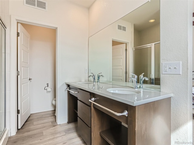 4628 Mt Shavano St, Brighton, CO 80601 - bathroom featuring double vanity, a shower stall, and wood finished floors