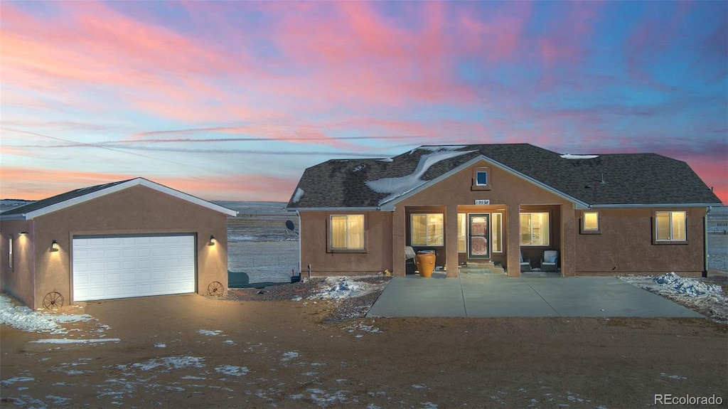 view of front of home featuring a garage and a patio area