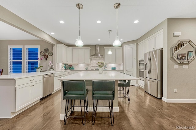 6470 Amur Ct, Castle Rock, CO 80108 - kitchen featuring appliances with stainless steel finishes, wall chimney exhaust hood, tasteful backsplash, a kitchen bar, and white cabinets