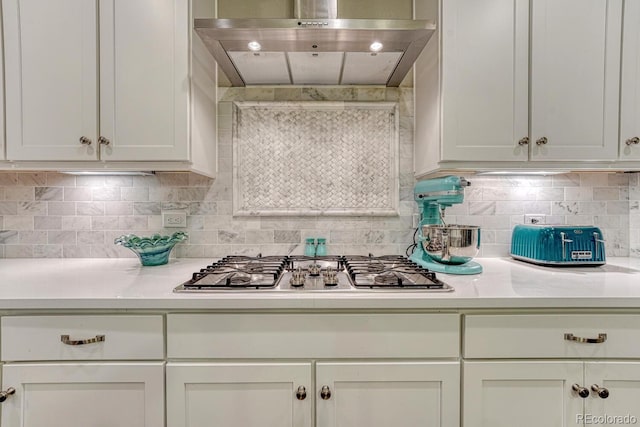 6470 Amur Ct, Castle Rock, CO 80108 - kitchen with range hood, light countertops, stainless steel gas stovetop, white cabinetry, and decorative backsplash