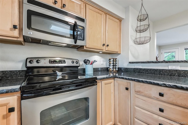 kitchen with stainless steel appliances, dark stone countertops, decorative light fixtures, and light brown cabinets