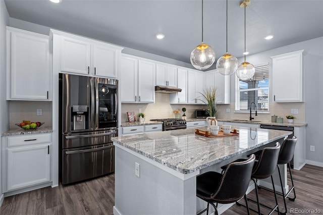 kitchen with white cabinetry, a center island, sink, dark wood-type flooring, and stainless steel appliances