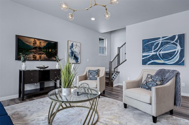 sitting room with hardwood / wood-style floors and an inviting chandelier