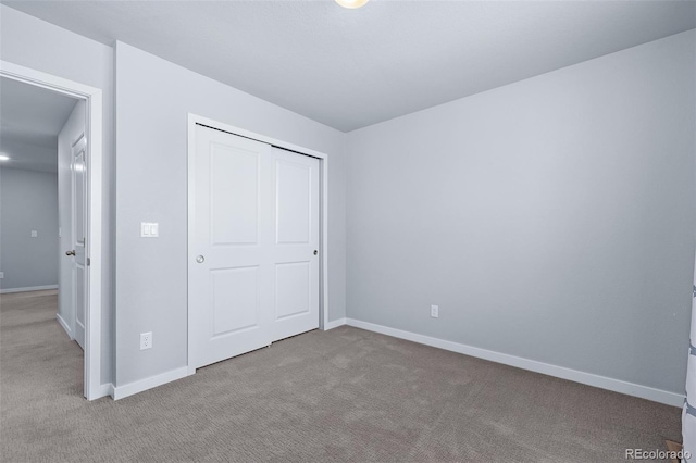 unfurnished bedroom with light carpet and a closet