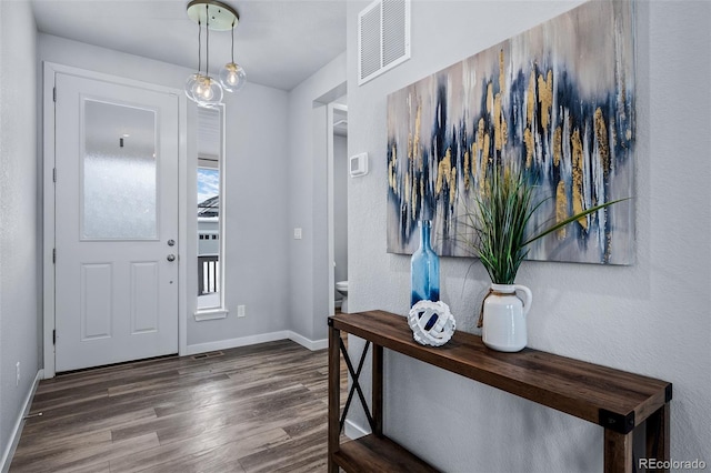 entrance foyer featuring visible vents, dark wood-type flooring, and baseboards