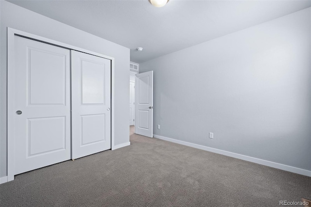 unfurnished bedroom featuring baseboards, carpet floors, and a closet