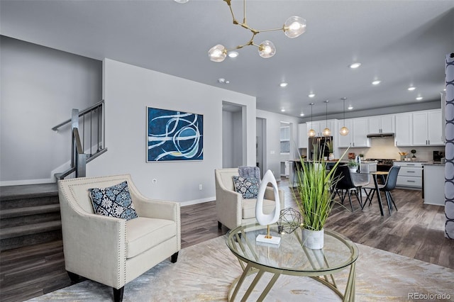 living room with dark wood-style floors, recessed lighting, stairway, an inviting chandelier, and baseboards