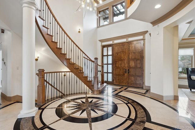 foyer with marble finish floor, decorative columns, recessed lighting, ornamental molding, and baseboards