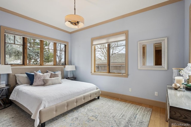 bedroom featuring ornamental molding, light wood-type flooring, and baseboards