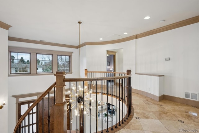 hallway with baseboards, visible vents, crown molding, and an upstairs landing