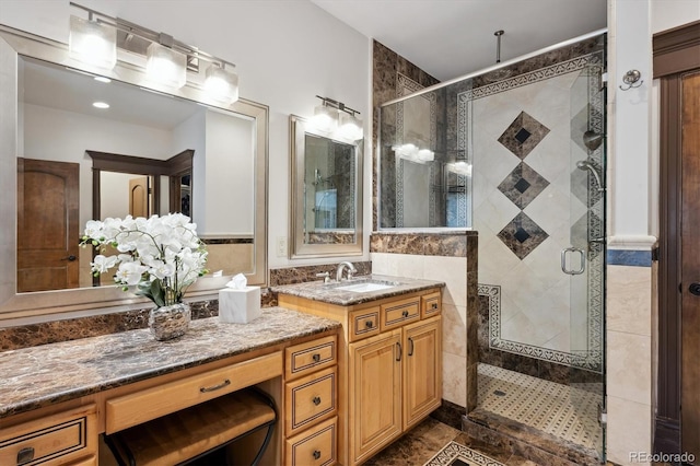 bathroom with a stall shower, tile walls, and vanity